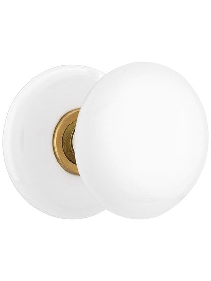 White Porcelain Rosette Door Set With White Porcelain Knobs in Antique Brass.